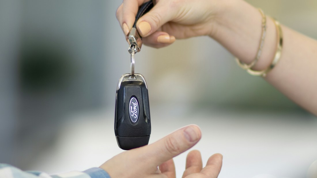 Une personne remettant une clé de voiture à une autre
